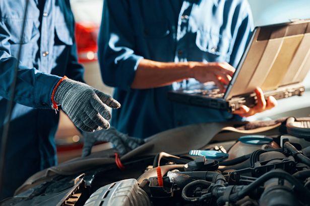 Car mechanics checking the engine of a car